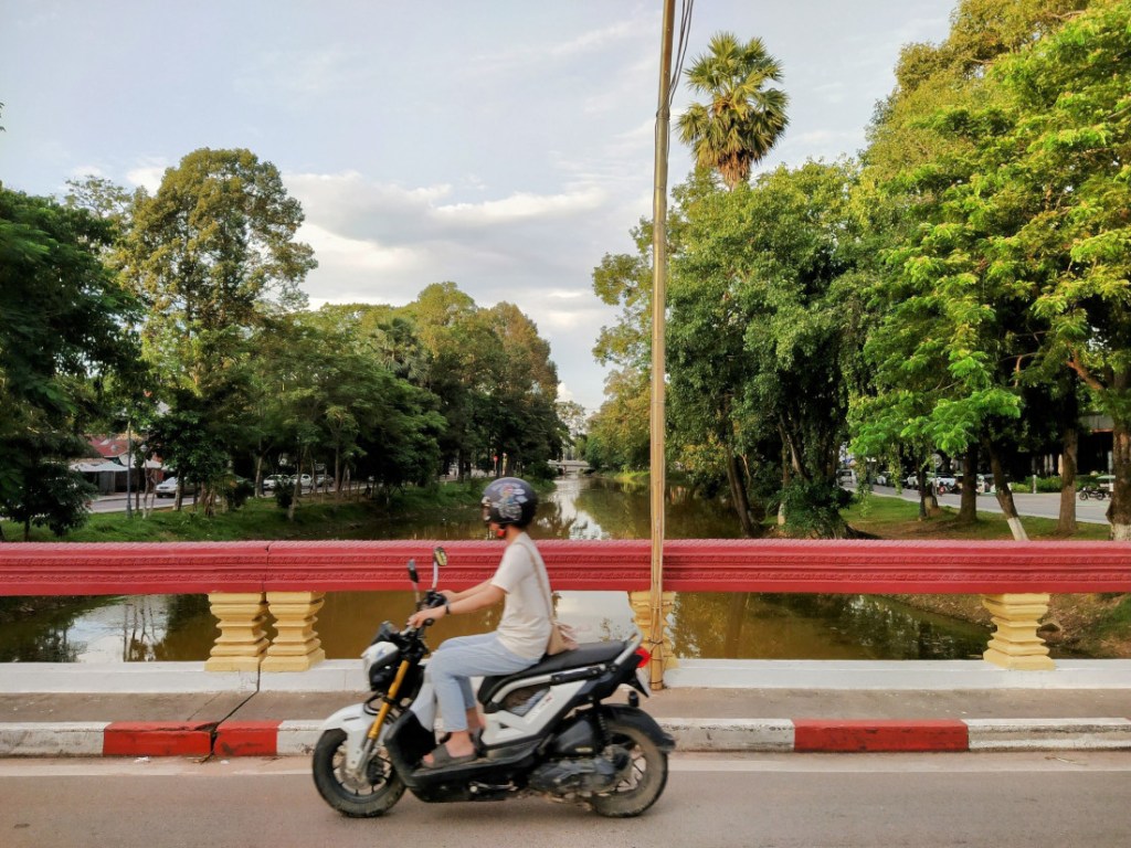 moto driving on a bridge over the siem reap river